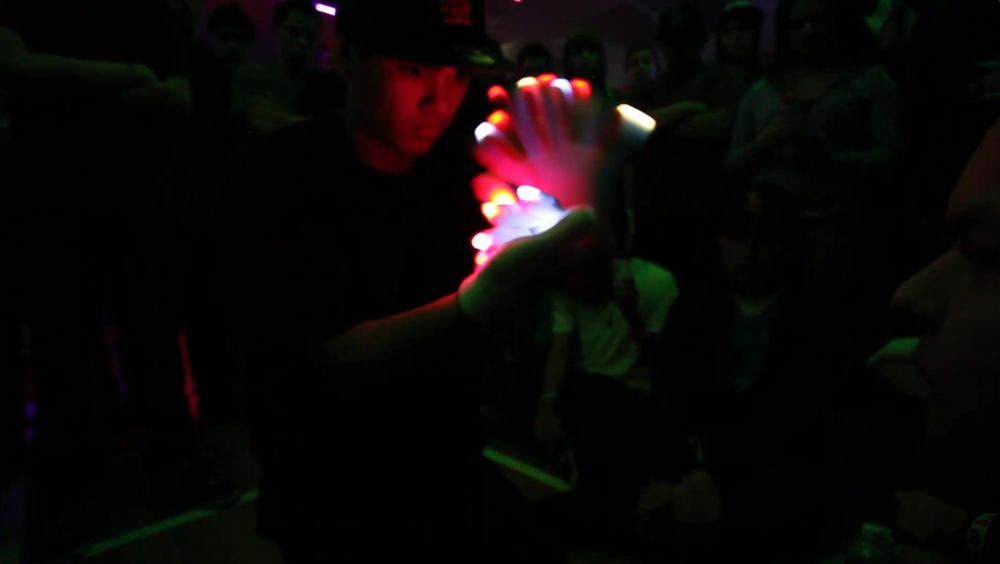 A glover mid-lightshow at a 2010s-era show or competition, crowd gathered around