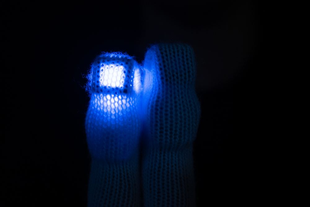 Close-up of an EXO diffuser's cube structure lit inside one glove finger, next to an unlit finger showing the 3D shape unlit