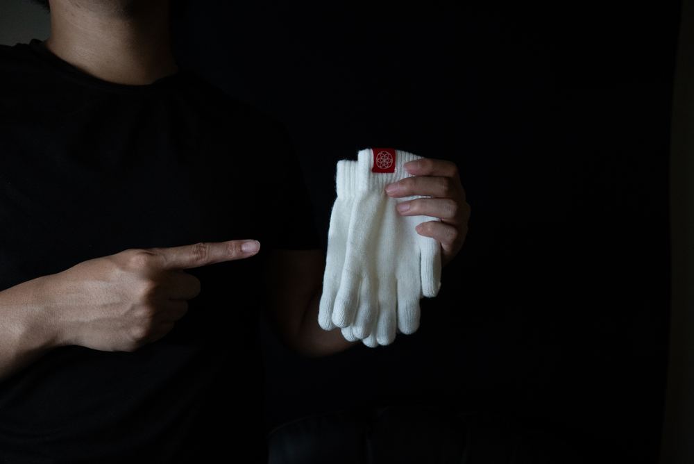 A candid moment between two people: one gesturing toward their gloves, the other reacting