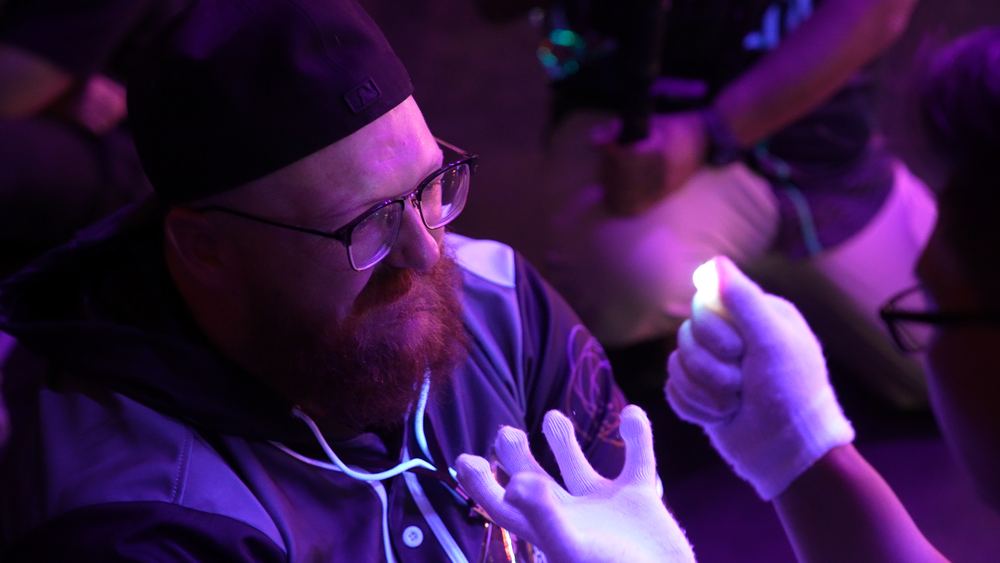 A viewer's face lit up by a glover's lightshow inches away, showing how close a real lightshow gets