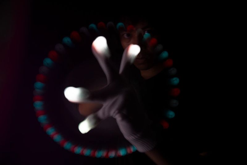 Glover mid-lightshow, hand shaped into a claw with a full circular light trail glowing around it